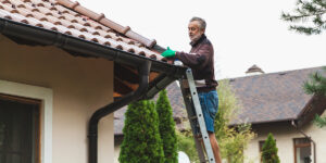 man standing on ladder performing a DIY roof repair